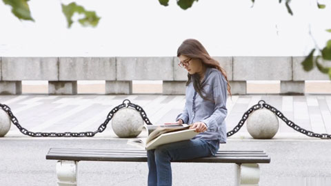 公园里长凳上工作的女孩